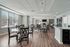 Bright and inviting community room with elegant wooden flooring, modern furnishings, and a cozy fireplace creating a perfect gathering space.