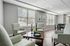 Elegant and cozy living room with soft armchairs, a stylish coffee table, and large sunlit windows, perfect for relaxation and socializing.