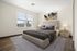 Elegant bedroom with a large window, modern artwork, and stylish decor creating a serene and inviting atmosphere.