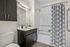 Modern bathroom featuring elegant fixtures, stylish cabinetry, and a patterned shower curtain for a contemporary feel.