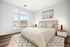 Bright and airy bedroom with a cozy bed, large window offering scenic views, and elegant decor creating a peaceful retreat.