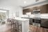 Modern open-plan living area with sleek kitchen, stylish breakfast bar, and cozy lounge. Bright, inviting space with elegant wooden flooring and contemporary decor.