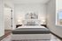 Elegant bedroom with modern decor, featuring a plush bed, chic artwork, and ample natural light.