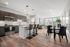 Modern open-concept kitchen and living area with sleek cabinetry, breakfast bar, and vibrant natural lighting.
