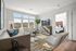 Bright, inviting living room featuring modern decor, natural light, and a view into a cozy bedroom.