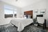 Bright and inviting bedroom with elegant decor, featuring a plush bed, stylish headboard, and a serene view through large windows.
