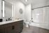 Modern bathroom with sleek dark wood vanity, large mirror with LED lighting, and chic wall art, featuring a spacious bathtub-shower combo with elegant tile work.