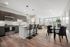 Modern open-plan kitchen and living area with sleek cabinetry, stylish bar seating, and abundant natural light from large windows.