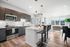 Modern open-plan kitchen and living area with sleek appliances, stylish bar seating, and floor-to-ceiling windows offering a scenic view.