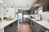 Sleek modern kitchen with stainless steel appliances, elegant cabinetry, and a spacious white island bench, perfect for entertaining.