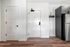 Modern apartment entryway with sleek white doors, elegant wood flooring, and a sophisticated kitchen glimpse with a wine rack.
