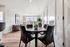 Bright and modern open-plan dining and living area with large windows offering scenic views, featuring elegant furniture and stylish decor.