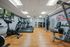 Modern fitness center with state-of-the-art exercise equipment, wooden flooring, and vibrant artwork on the walls.