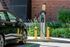Modern electric vehicle charging station in a lush, green urban setting, highlighting eco-friendly amenities.