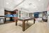 Chic apartment lounge with modern kitchen, elegant billiards table, and cozy seating area.