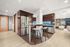 Contemporary open-concept kitchen with stainless steel appliances, sleek bar seating, and elegant wood cabinetry.