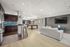 Stylish modern apartment with open-concept living area, featuring a sleek kitchen, elegant seating, and a pool table for entertainment.