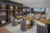 Sophisticated lounge area with modern decor, featuring plush seating, stylish round tables, and elegant book display in an upscale apartment.