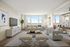 Bright and modern living room featuring plush seating, stylish decor, a large window with scenic views, and a cozy workspace.