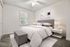 Inviting bedroom with elegant décor, plush carpet, and natural light filtering through a window, offering a serene and cozy atmosphere.