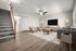 Bright and inviting living room with modern wooden flooring, cozy seating area, stylish decor, and natural light pouring in.