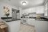 Bright and inviting kitchen with sleek black countertops, modern appliances, and cozy breakfast bar.