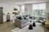 Modern open-concept living room and kitchen with sleek white cabinetry, stylish decor, and a cozy sofa perfect for relaxation.