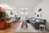 Chic, modern living space featuring a cozy gray sectional, elegant decor, and a breakfast bar with stylish seating.