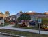 Charming residential building with welcoming entrance, surrounded by vibrant autumn landscaping and reserved parking.