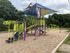 Vibrant playground featuring colorful climbing structures and slides, nestled in a lush green park, perfect for family fun and outdoor activities.