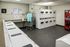 Modern apartment laundry room with multiple washers and dryers, sleek countertops, and a convenient vending machine.