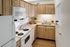 Charming kitchen with elegant wooden cabinets, modern appliances, and a cozy ambiance complete with vibrant decor.