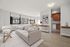 Bright and inviting living room with large windows, modern furnishings, and an open layout leading to a cozy dining area and chic kitchen.
