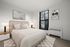 Inviting bedroom featuring a plush bed with elegant linens, ambient lighting from stylish lamps, and chic wall art, creating a serene retreat.