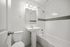 Elegant bathroom with modern fixtures, a sleek pedestal sink, and clean white tile design.