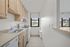 Bright, modern kitchen featuring sleek cabinetry, spacious countertops, and large window with serene views.