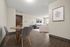 Modern open-concept living room with hardwood floors and stylish furnishings, featuring a cozy dining area and elegant wall art.