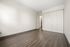 Inviting bedroom with sleek laminate flooring, ample closet space, and a neutral palette offering versatile design potential.