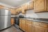 Contemporary kitchen with stainless steel appliances, granite countertops, and natural wood cabinets.