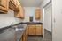 Charming kitchen with warm wood cabinets, sleek granite countertops, and stainless steel sink, perfect for culinary enthusiasts.