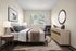 Inviting bedroom featuring elegant decor, large window with serene tree views, and modern furnishings for a tranquil retreat.