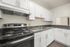 Modern kitchen featuring sleek white cabinetry, stainless steel appliances, and elegant granite countertops.