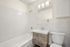 Bright, modern bathroom featuring a sleek vanity, full bathtub, and elegant lighting fixtures.