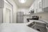 Bright modern kitchen with stainless steel appliances, sleek white cabinetry, and elegant countertops.