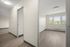 Bright and inviting room with large windows overlooking lush greenery, featuring sleek hardwood floors and elegant, modern lighting.