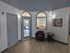 Inviting lobby area with stylish gray doors, modern wood flooring, and a cozy leather chair, perfect for welcoming guests.