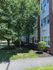 Charming brick apartment building surrounded by lush greenery, offering tranquility and natural beauty.