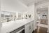 Bright and inviting living space with elegant decor, large windows, and modern kitchen counter detail.