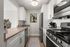 Sleek and modern kitchen with stainless steel appliances, elegant white cabinetry, and stylish artwork, offering a perfect blend of functionality and design.