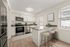 Modern kitchen with granite countertops, sleek stainless steel appliances, and elegant bar seating under natural light.